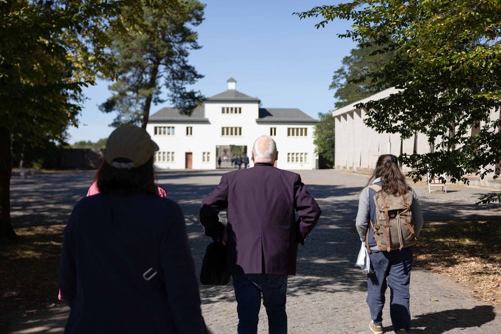 Teilnehmende eines Treffens von Nachkommen vor dem historischen Eingang zum Lager, Gedenkstätte Sachsenhausen, 2024, Foto: Leona Goldstein.