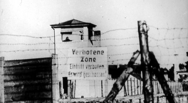 Stacheldrahtzaun vor dem Speziallager Sachsenhausen mit Schild „Verbotene Zone“ und Wachturm, Richard Perlia Mai/Juni 1949